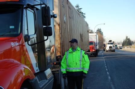 Officer standing beside a truck on the road