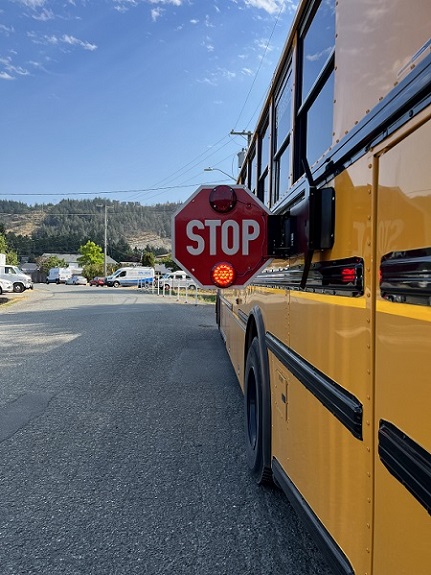 Rear view of school bus with stop sign out.