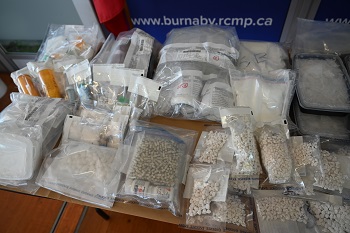 Numerous bags and bottles of various drugs laid out on a table.