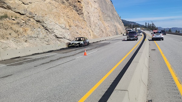 Burnt car and emergency vehicles on highway 97