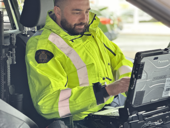 Richmond RCMP officer sitting in a police car issuing a traffic ticket