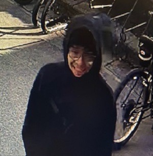 front view of suspect upper body in dark hoody-bicycles in the back ground