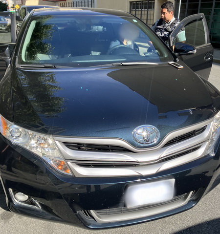 Toyota noire arrêtée avec un policier parlant au conducteur