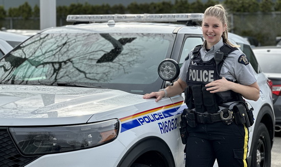 Constable Tara Joubert standing beside a marked police vehicle