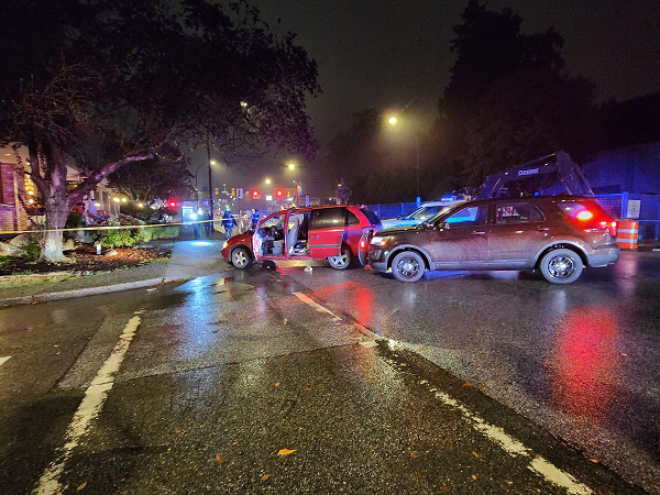 Picture of a red dodge caravan that crashed into a sidewalk with two police vehicles behind it. 