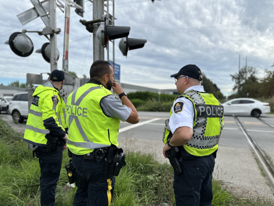 Richmond RCMP officer standing with CN Police at railway crossing