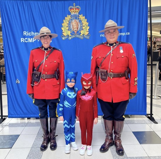 Des policiers debout avec deux enfants qui portent des costumes