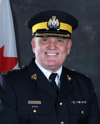 Photo du surintendant principal Bruce Singer souriant en uniforme de police et coiffé d’une casquette de police.