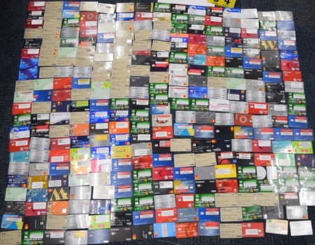 Over three hundred blurred bank cards displayed on the floor.