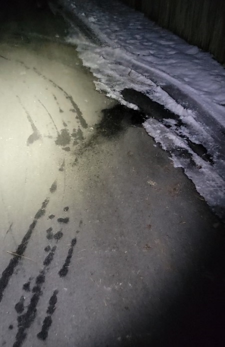 Distinctive fluid trail in an alley with snow on the upper right part of the photo.