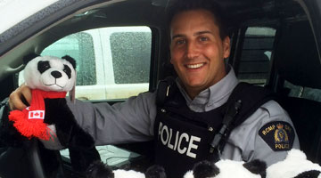 Cst. Borelli from Fort St. James RCMP delivering donated Panda bears.