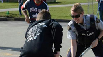 Richmond RCMP members and McKinney Elementary students playing hockey