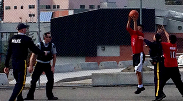 Williams lake RCMP and teens playing basketball