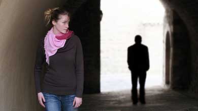 Personne marchant avec la silhouette noire d’une autre personne derrière elle.