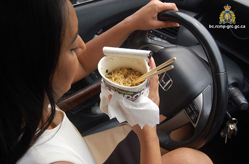 Une femme mange des nouilles pendant qu’elle conduit.