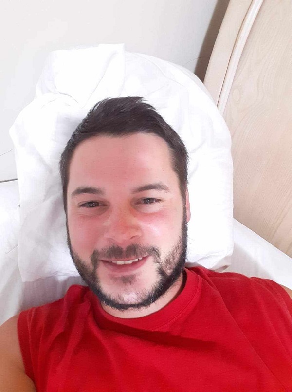 First Nations male with facial hair wearing red t-shirt