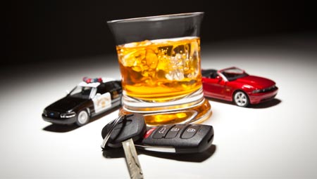 Car keys, model police car, model convertible, alcoholic beverage