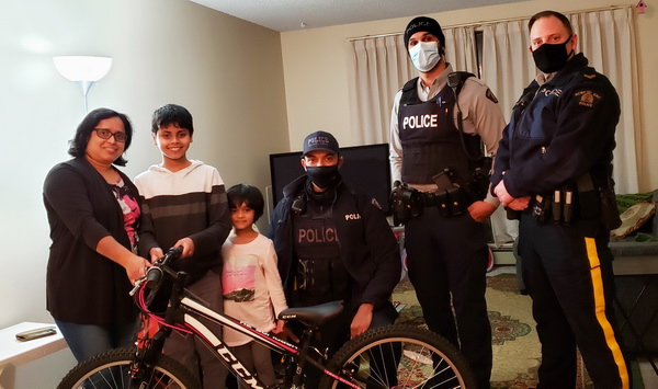Sabit, 12, with his mother, sister and members of the Richmond RCMP