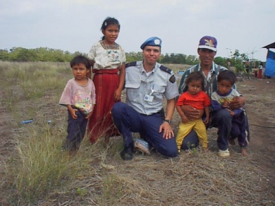 Photo of Inspector Maure visiting with a family of an ex-combatant.