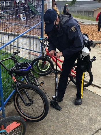 Police officer helps fix bikes 