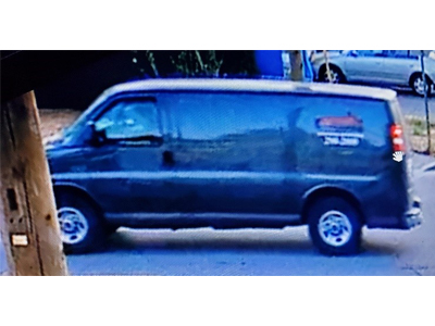 Photo of the dark coloured GMC van, with logos on the side
