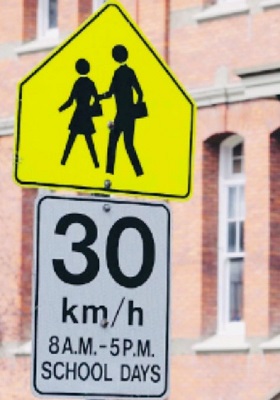 School zone sign showing posted speed of 30 km/h 