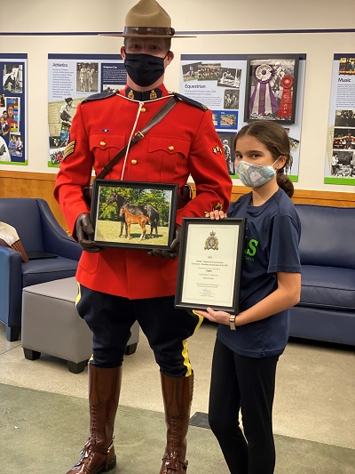 rcmp member in red serge with winner of foal contest