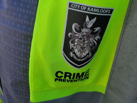 A neon yellow shoulder patch with the City of Kamloops Crime Prevention logo. 