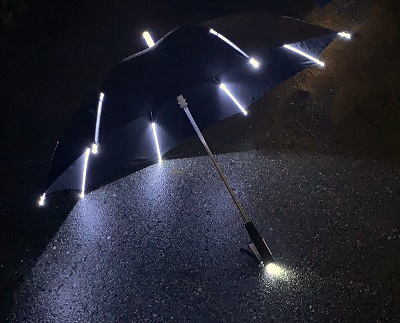 An umbrella with built in lights opened on the street.