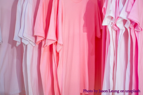 Photo of pink t-shirts hanging in a row