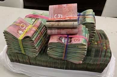 Photo of about $100K CND currency in bundles