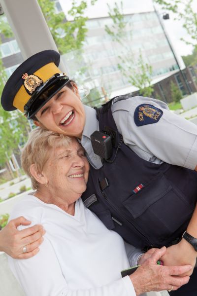 Stock image of an RCMP officer hugging a woman.