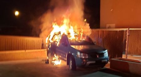 A blue SUV fully engulfed in flames.