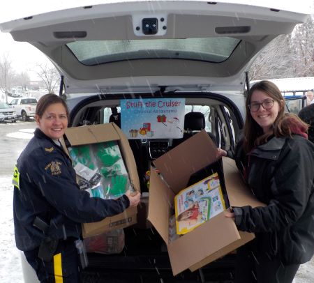 Corporal Crystal Evelyn and Morgan Endean load boxes of gifts, donated by the Real Canadian Superstore in Kamloops, into the back of a Crime Prevention van.