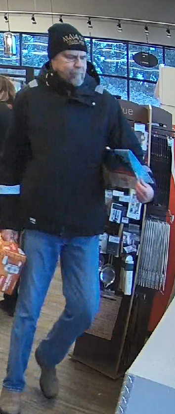 James Cheetham wearing a black jacket, black touque, blue jeans and carrying a bag and beer case