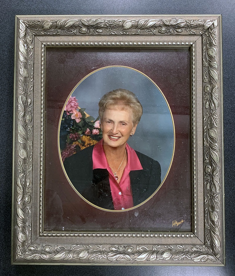 Photographie encadrée d’une femme portant un blazer de couleur foncée et un chandail rose vif