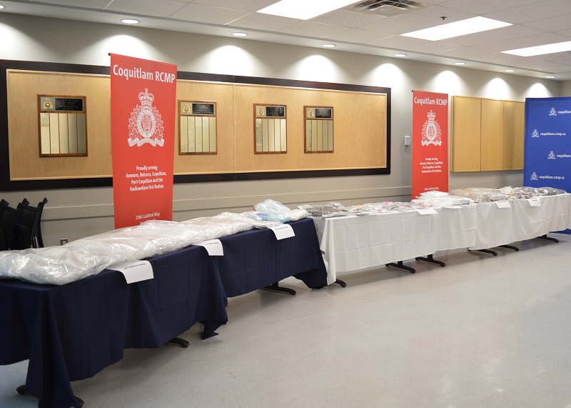 Various seized drugs in clear plastic exhibit bags laid out on a table