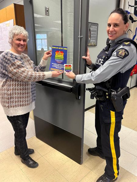 From left, Vessy Mochikas, Assistant Superintendent of Inclusive Education, and Kamloops RCMP Corporal Dana Napier put Safe Place Rainbow Shields on a school doorway in preparation for Pink Shirt Day, Feb. 22.   