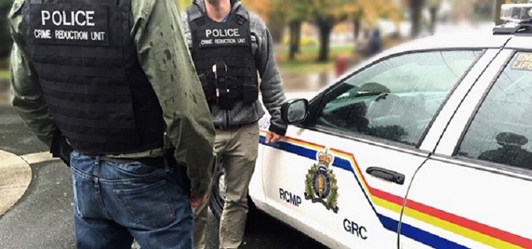 Two police crime reduction unit officers standing in front of a police car