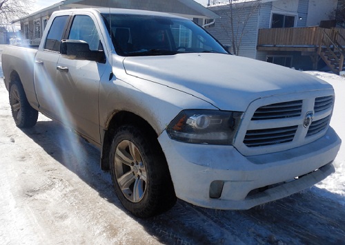 Recovered white 2014 Dodge Ram 1500 in the sunlight