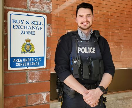  Kamloops RCMP Cst. Justice Lesuk positions a ‘Buy and Sell Exchange Zone’ sign on the wall in the front lobby of the Battle Street RCMP detachment.