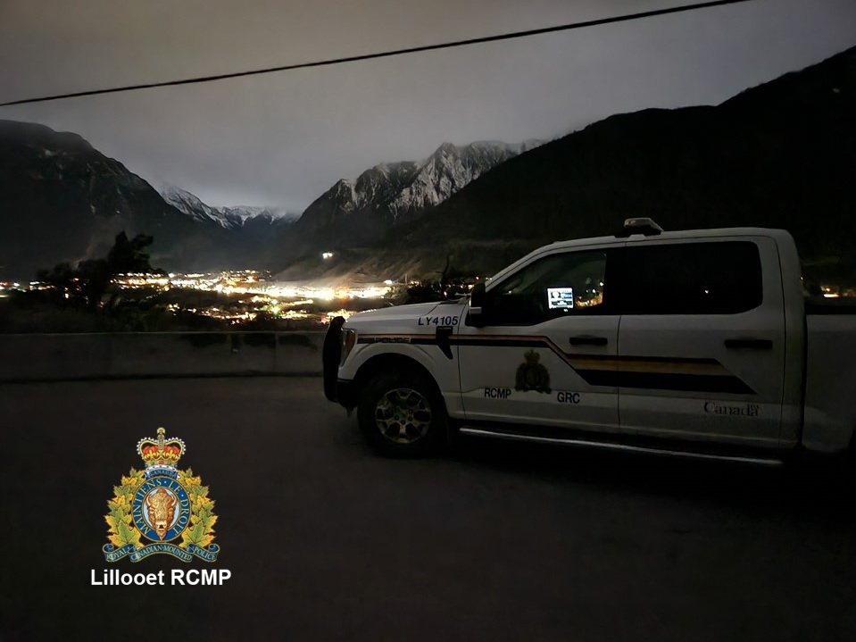 View of police vehicle with Lillooet at night in background.