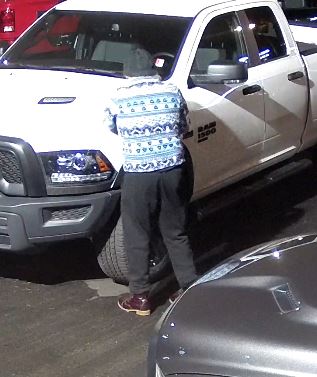 Photo tirée de la vidéo montrant la suspecte de dos, portant un chandail bleu et blanc, un pantalon noir et une tuque noire