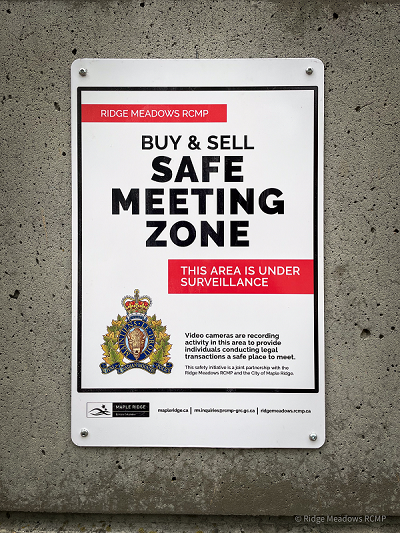 new "Buy and Sell Safe Zone" sign near the Ridge Meadows RCMP detachment reading "Buy & Sell Safe Meeting Zone"