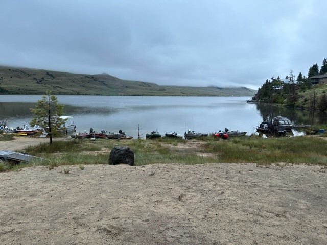 Stump lake with fishing boats lined up on the shoreline.
