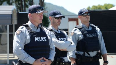 Three male police officers standing together.