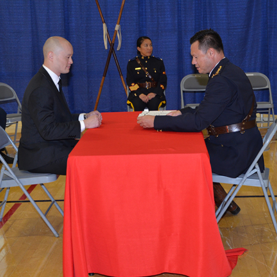 A male police officer signing his engagement papers to join the RCMP.