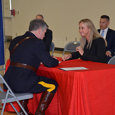 A female police officer signing her engagement papers to join the RCMP.