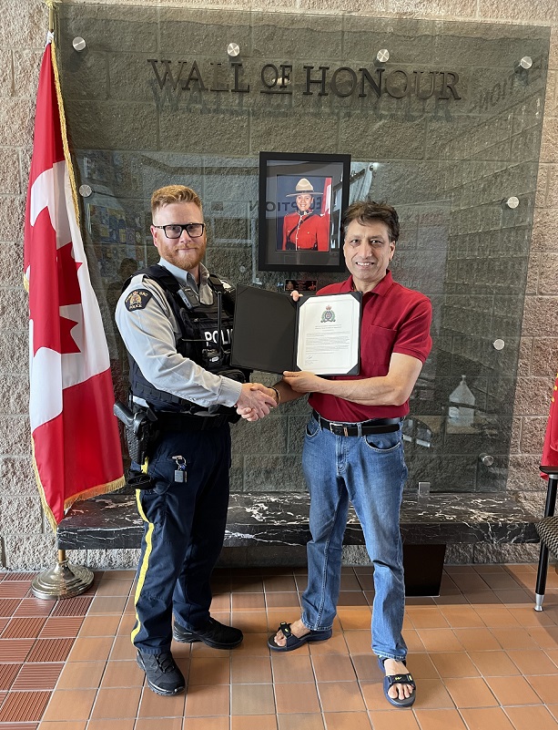 Cst. Renner presenting Certificate of Appreciation to Mr. Bharmota