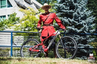 Sgt. David Vunic en tunique rouge avec sa bicyclette